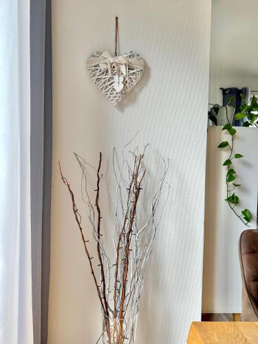 a vase with branches and a heart on a wall at Ferienhaus Oldenburg in Oldenburg
