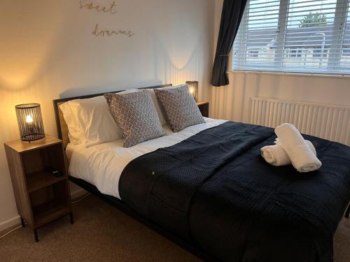 a bedroom with a bed with a towel on it at CONTRACTORS OR FAMILY HOUSE M1 Nottingham - IKEA RETAIL PARK - SWINDON CLOSE - 2 Bed Home with Driveway, private garden, sleeps 4 - TV'S in all rooms in Giltbrook