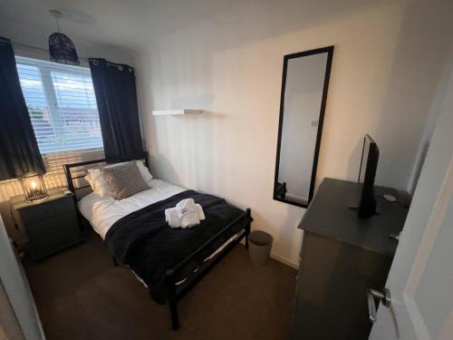 a small bedroom with a bed and a mirror at CONTRACTORS OR FAMILY HOUSE M1 Nottingham - IKEA RETAIL PARK - SWINDON CLOSE - 2 Bed Home with Driveway, private garden, sleeps 4 - TV'S in all rooms in Giltbrook