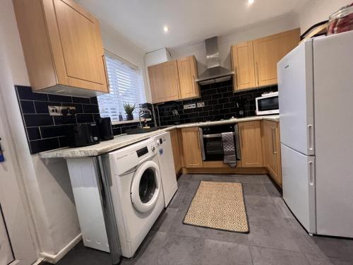 eine Küche mit einer Waschmaschine und einem Kühlschrank in der Unterkunft CONTRACTORS OR FAMILY HOUSE M1 Nottingham - IKEA RETAIL PARK - SWINDON CLOSE - 2 Bed Home with Driveway, private garden, sleeps 4 - TV'S in all rooms in Giltbrook