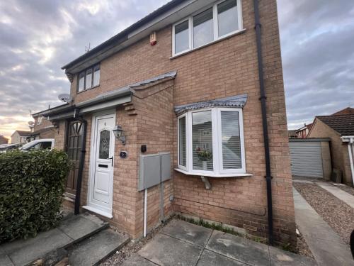 a brick house with a white door and windows at CONTRACTORS OR FAMILY HOUSE M1 Nottingham - IKEA RETAIL PARK - SWINDON CLOSE - 2 Bed Home with Driveway, private garden, sleeps 4 - TV'S in all rooms in Giltbrook