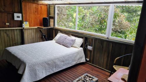 a bedroom with a bed and two windows at Sukha Glamping in Rionegro