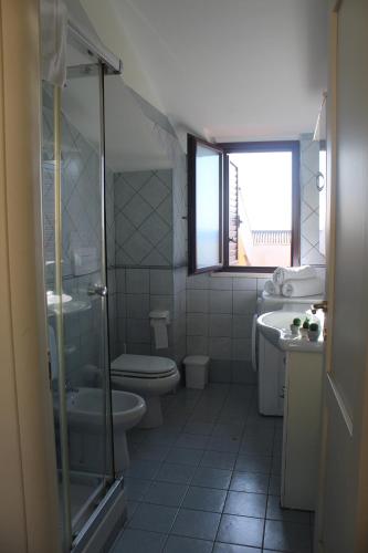 uma casa de banho com um WC e uma janela. em Il Borgo della Marinella Case Vacanze em Amantea