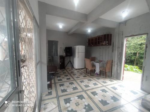 uma sala de estar com piso em azulejo e uma cozinha em Casa Ariramba Mosqueiro em Belém