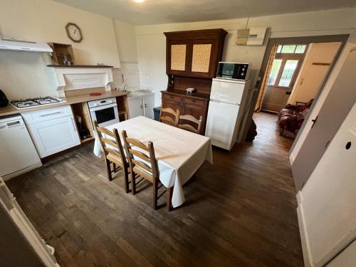 uma cozinha com uma mesa e cadeiras em maison de campagne em Saint-Martin-Château