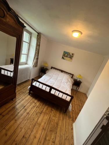 um quarto com uma cama e piso em madeira em maison de campagne em Saint-Martin-Château