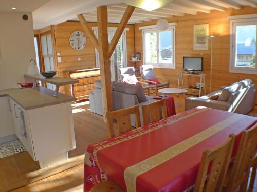 - un salon avec une table, des chaises et une télévision dans l'établissement Chalet Gentiane à Samoëns - Idéal pour vacances familiales ou entre amis, calme et confort assuré - FR-1-629-88, à Samoëns
