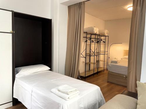 1 Schlafzimmer mit 2 Betten und weißer Bettwäsche in der Unterkunft Apartamento Calma Carihuela Beach - 10 metros de la playa in Torremolinos