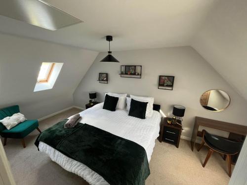 ein Schlafzimmer mit einem Bett, einem Stuhl und einem Spiegel in der Unterkunft Buckthorn House - James Cook Hospital in Middlesbrough
