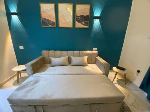 uma cama grande num quarto com uma parede azul em Cozy apartment in down town no Cairo