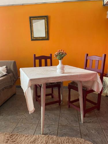 uma mesa de jantar com um vaso de flores em Soul Habitaciones em Ezeiza