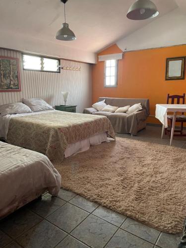 a large bedroom with two beds and a couch at Soul Habitaciones in Ezeiza
