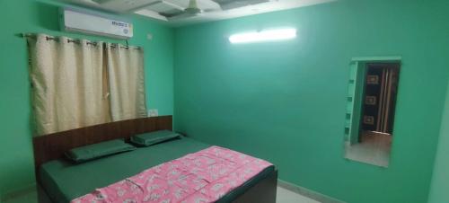 a bedroom with a bed in a blue room at RUSHITHA HOME STAY-AC Rooms-FREE WIFI-FLAT TV- KITCHEN-DOOR SERVICE-NEAR TO ALIPIRI in Tirupati