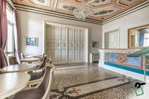a dining room with tables and chairs and a ceiling at HOTIDAY Room Collection - Livorno Mascagni in Livorno