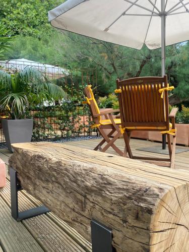 a patio with two chairs and an umbrella at Hotel Arimune in Bakio