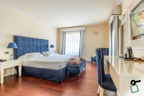 a hotel room with a large bed and a desk at HOTIDAY Room Collection - Livorno Mascagni in Livorno