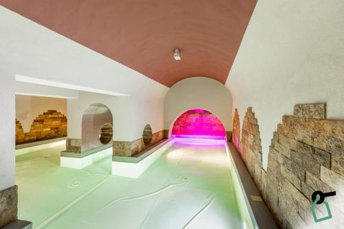 einen Innenpool in einem Gebäude mit rosa Licht in der Unterkunft HOTIDAY Hotel Livorno in Livorno