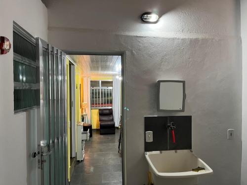 a bathroom with a sink and a toilet in a hallway at Anjos Dourados Apartment in Mangaratiba