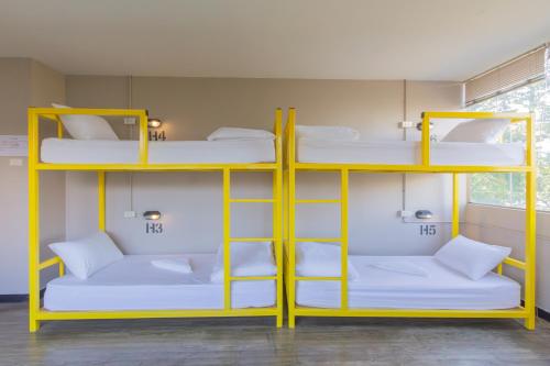 a room with three bunk beds and a window at Chang Chang Hostel in Chiang Mai