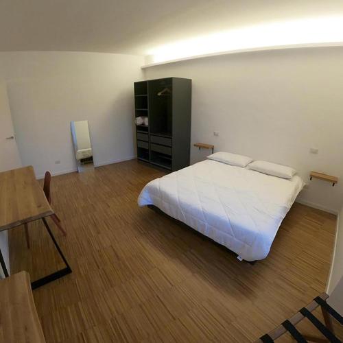 a bedroom with a white bed and a wooden floor at Colonia Iulia in Spello