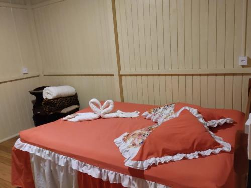 Una cama con toallas encima en una habitación en Pousada Flor da Serra en Urubici