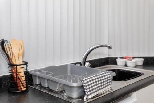 a kitchen sink with a dish drying rack next to it at No 1 Thornhill House in Hartlepool