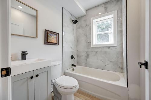 biała łazienka z wanną, toaletą i umywalką w obiekcie Brand New Home in Hamilton w mieście Hamilton