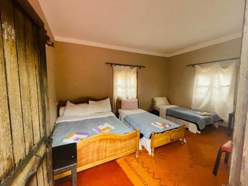 1 dormitorio con 2 camas en una habitación en Riad Les Roches Todra, en Tinerhir