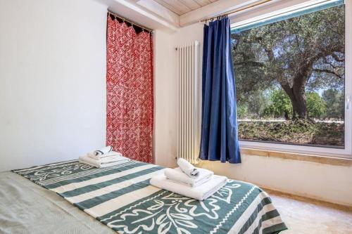 a bedroom with two beds and a window at Trullo Cristiana in Latiano