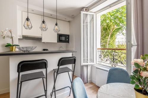 une cuisine avec une table et des chaises et une fenêtre dans l'établissement 1 bedroomed Apartment Repos, à Paris