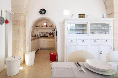 a kitchen with a table and a white cabinet at Trullo Cristiana in Latiano
