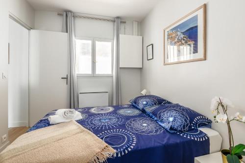 une chambre avec un lit bleu avec des oreillers bleus dans l'établissement 1 bedroomed Apartment Repos, à Paris