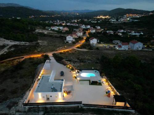 an aerial view of a large white house with lights at Villa VERONICA with CINEMA PROJECTOR by the HEATED POOL and JACUZZI in Šibenik