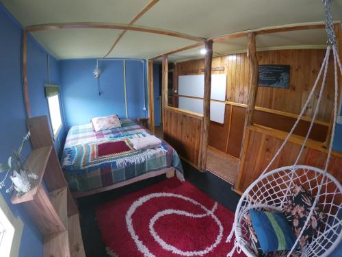Habitación pequeña con cama y columpio en Cabahostel Los Pinos #2, en Ancud