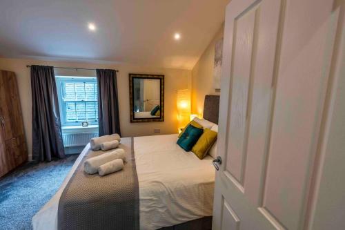 una camera da letto con un letto con due cuscini sopra di Cosy Cottage in Central Kendal with Parking! a Kendal