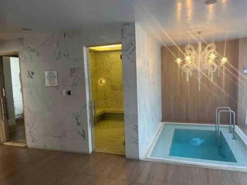 bagno con vasca idromassaggio e lampadario pendente di Alojamiento sin estrés de lujo a Quito