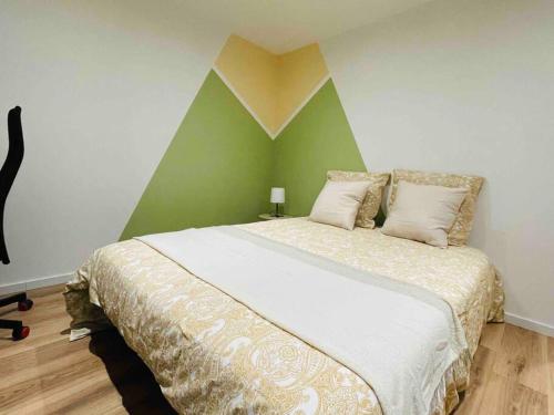 a bedroom with a large bed with a green wall at Come & chill in Belfort