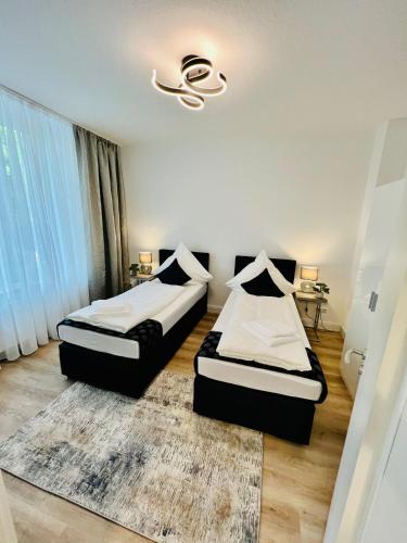 een slaapkamer met 2 bedden en een kroonluchter bij Nd Hotels & Apartments Oberstrasse Mülheim in Mülheim an der Ruhr