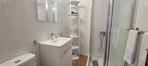 La salle de bains blanche est pourvue d'un lavabo et d'une douche. dans l'établissement Sabbia Suites Barlovento, à Famara