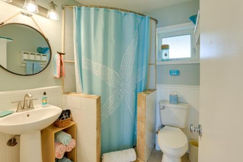 La salle de bains est pourvue d'un lavabo, de toilettes et d'un miroir. dans l'établissement Tropical Hobe Sound Cottage Less Than 2 Mi From the Beach, à Hobe Sound