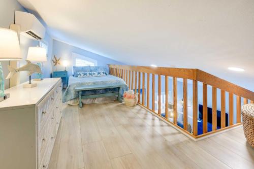 Cette chambre bleue dispose d'un escalier en bois et d'un lit. dans l'établissement Tropical Hobe Sound Cottage Less Than 2 Mi From the Beach, à Hobe Sound