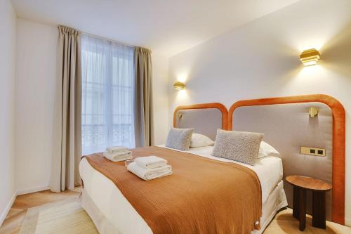 une chambre d'hôtel avec un lit avec des serviettes dessus dans l'établissement Luxurious Apartment - 3BDR-8P - Bastille, à Paris
