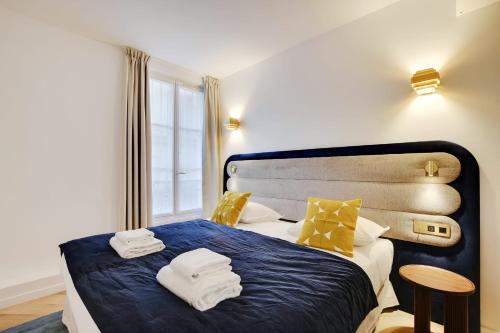 une chambre avec un lit bleu avec des serviettes dessus dans l'établissement Luxurious Apartment - 3BDR-8P - Bastille, à Paris