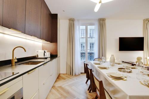 a kitchen with a long table with chairs and a sink at Stunning fully renovated apartment 8P Paris 11 in Paris