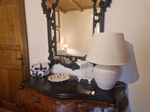 une lampe au-dessus d'une table avec miroir dans l'établissement Cacciatrici di orizzonti casa vacanze, à Lanuvio