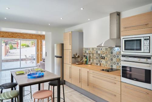 uma cozinha com armários de madeira e uma mesa com bancos em Paradis Champenois em Damery