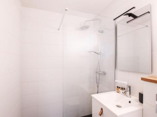 uma casa de banho branca com um chuveiro e um lavatório. em Appartement Chamonix-Mont-Blanc, 2 pièces, 4 personnes - FR-1-343-230 em Chamonix-Mont-Blanc