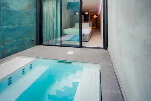 a swimming pool in a room with a bedroom at AGORA Tournai - Wellness Suites in Tournai