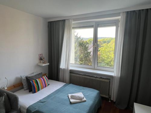a bedroom with a bed and a large window at Stylish Youthful Condo in the Heart of Mödling, Fiatalos Boldog Otthon Mödling Szivében in Mödling