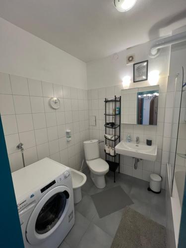 a bathroom with a washer and a washing machine in it at Stylish Youthful Condo in the Heart of Mödling, Fiatalos Boldog Otthon Mödling Szivében in Mödling